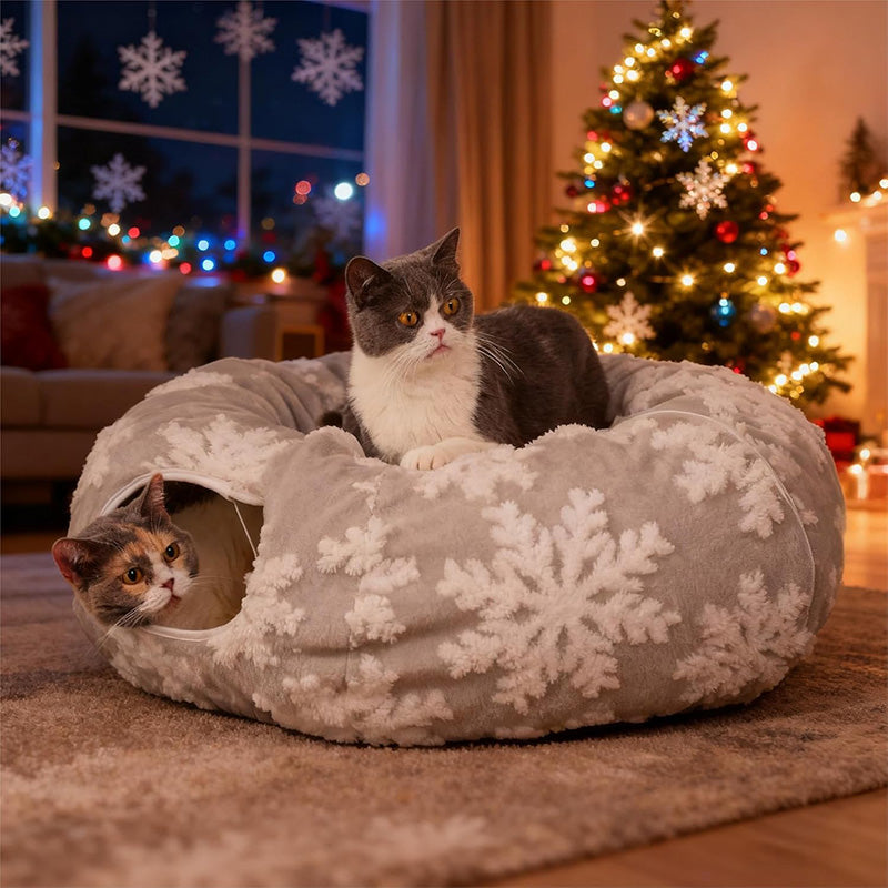 Two cats in a snowflake-patterned pet bed with a Christmas tree in the background